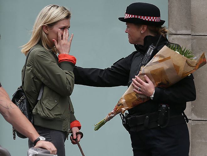 Nữ sĩ quan Cảnh sát an ủi một phụ nữ tới đặt hoa gần Cầu London ở London (Anh) để tưởng niệm các nạn nhân trong vụ tấn công khủng bố ngày 3-6-2017