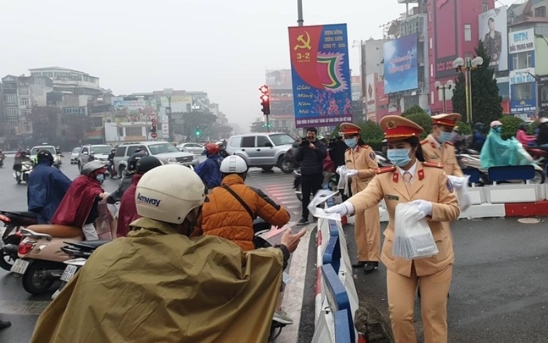 Các nữ cán bộ, chiến sĩ phòng CSGT Công an thành phố Hà Nội tổ chức phát khẩu trang miễn phí cho người dân ở ngã 6 Ô Chợ Dừa.